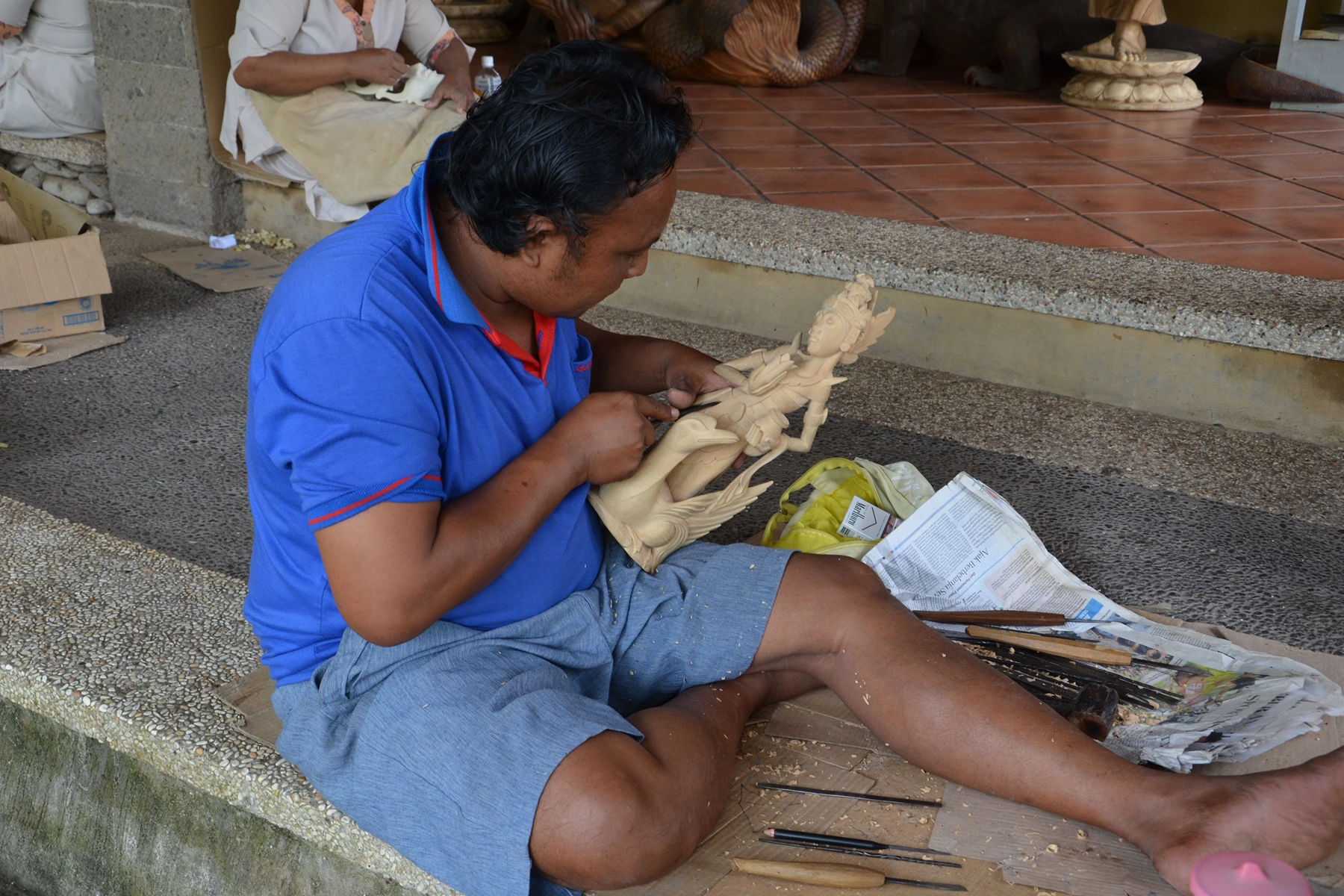 Balinese wood carver shaping a wooden sculpture in Mas Village near Ubud